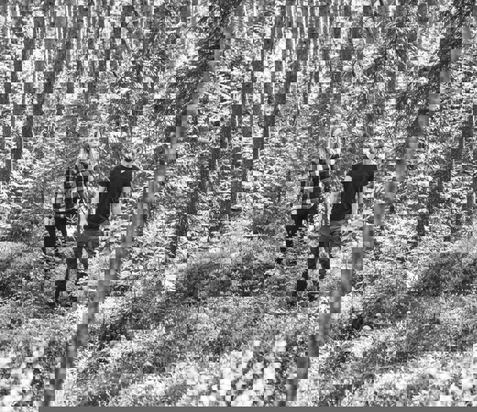 Man och kvinna går genom skogen.